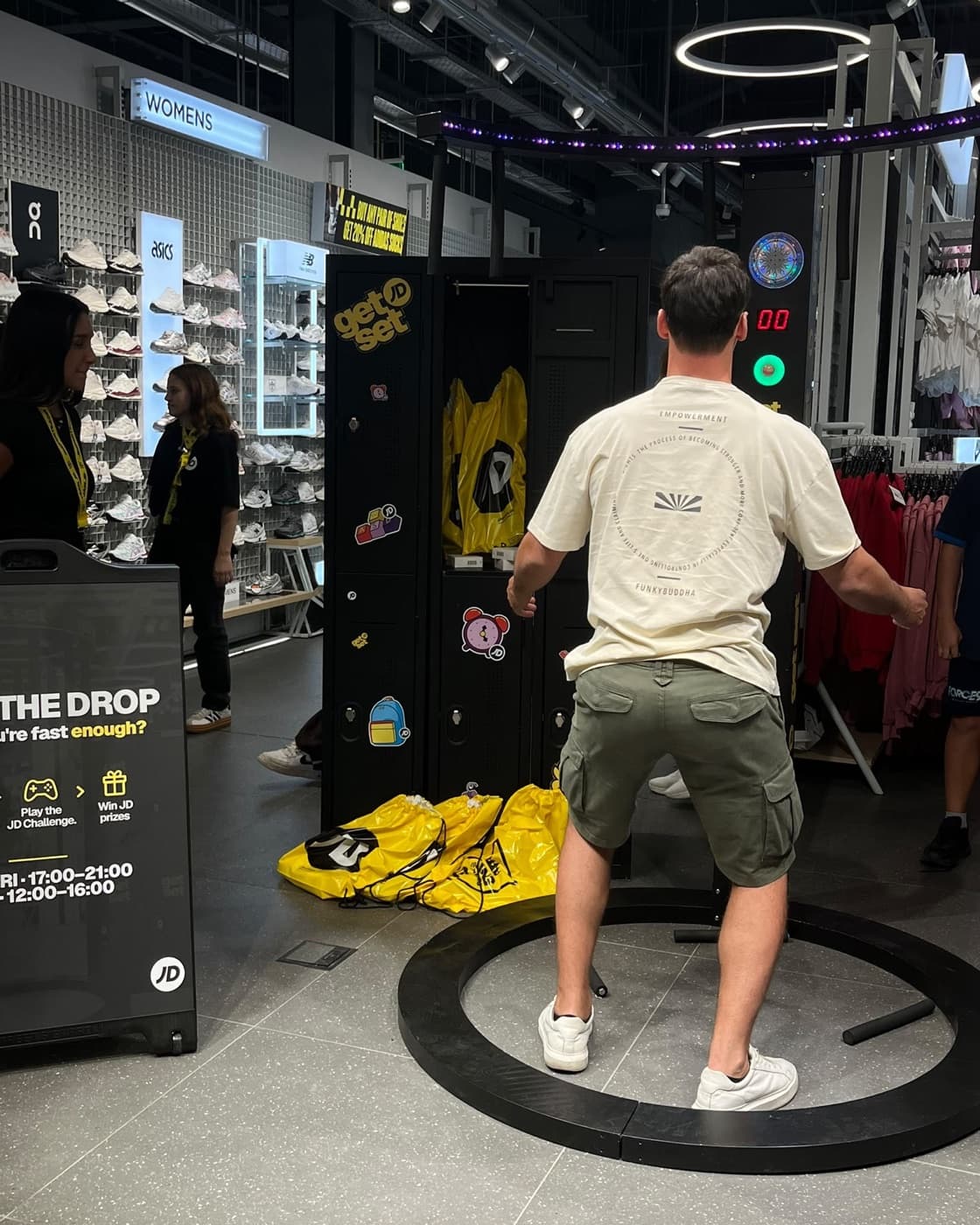 A player crouched in the ready stance inside the ring, sticks on the floor, next to the Beat the Drop sign